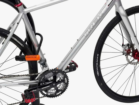 Silver electric bike secured with Kryptonite U-lock, Pogo Cycles e-bike security accessory