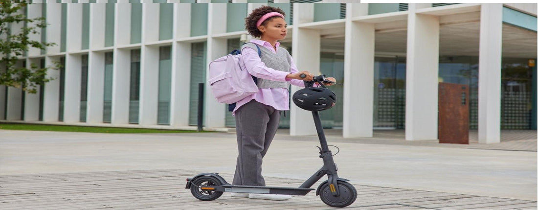 Young woman with backpack standing next to electric scooter outside modern building, Pogo Cycles