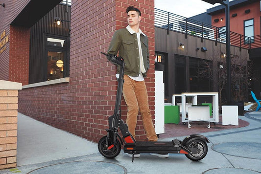 Man with black electric scooter outdoors in urban setting, Pogo Cycles e-scooter shop